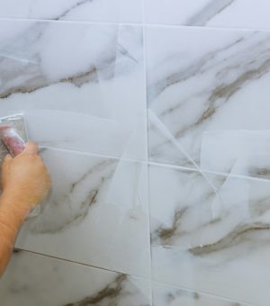 grouting-tiles-male-hand-with-the-rubber-applies-g-YDQMKVB